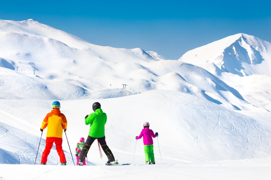 Family on winter ski vacations in ski slopes in Alps, Vogel, Slovenia, Europe.