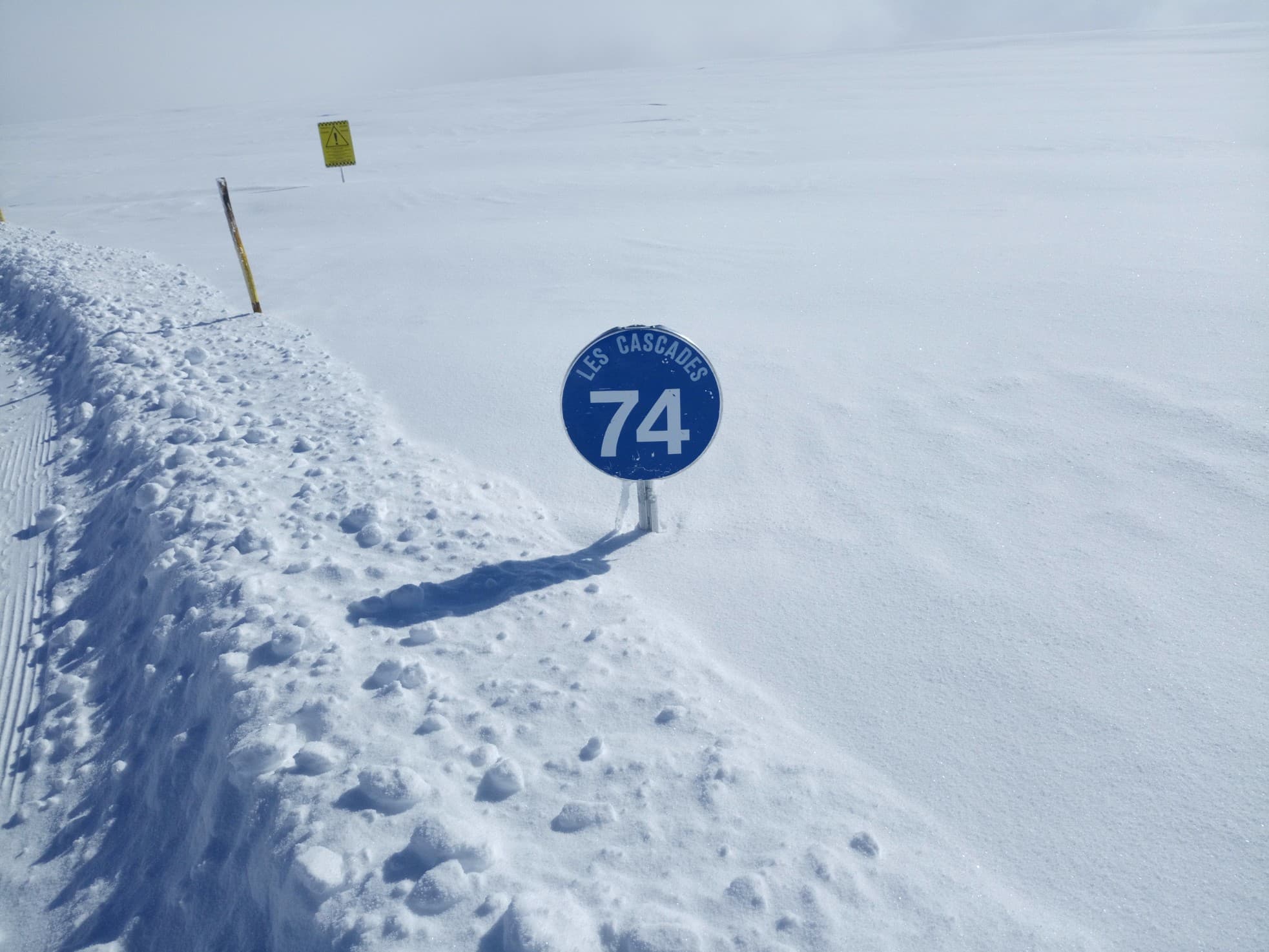 Piste de ski avec un panneau de signalisation de couleur bleue