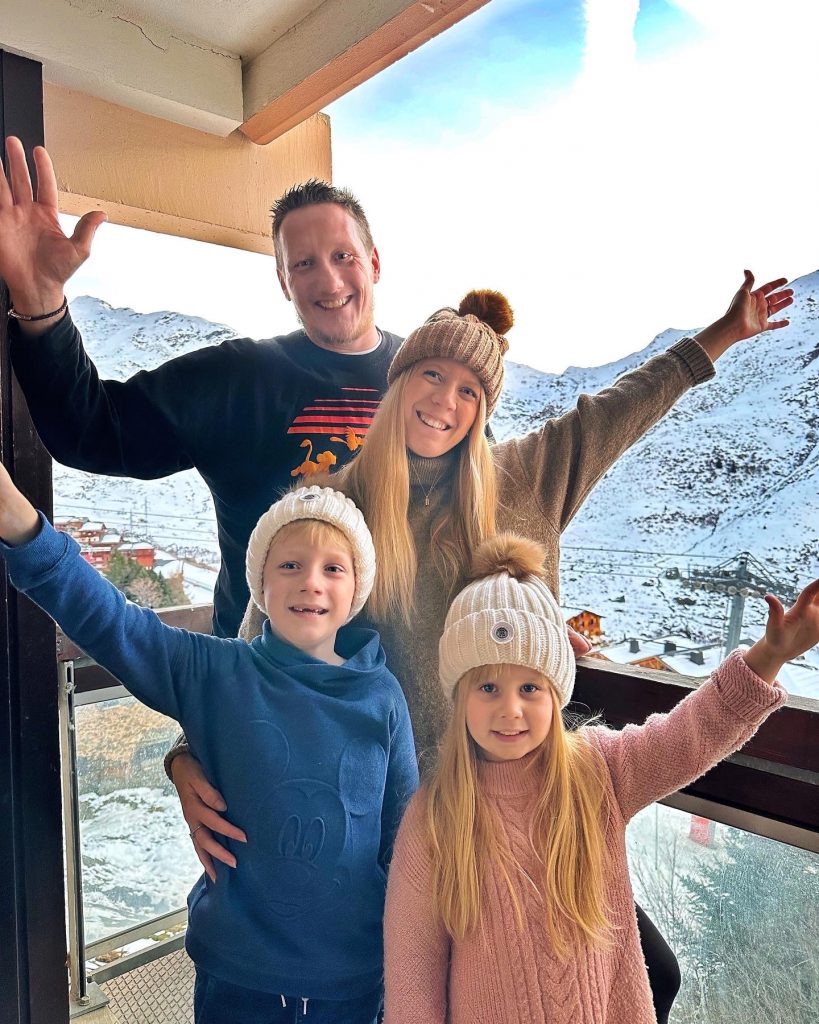 Une famille au ski, un couple avec leurs deux enfants aux Ménuires